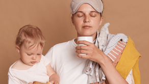 Une femme tient son bébé et boit un café, les yeux fermés