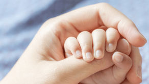 Une maman tient la main de son nouveau-né