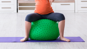 Une femme asssise sur un ballon de fitness