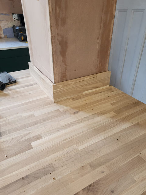 Bespoke oak worktop column boxing fitted into a kitchen to conceal structural pillar with seamless joinery detail