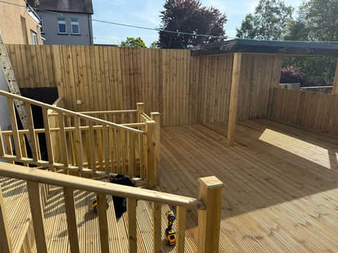 Timber decking installation with matching timber balustrade and steps forming a raised outdoor seating area