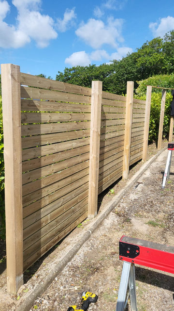 Close-up of slatted timber fencing showing evenly spaced boards and solid timber posts
