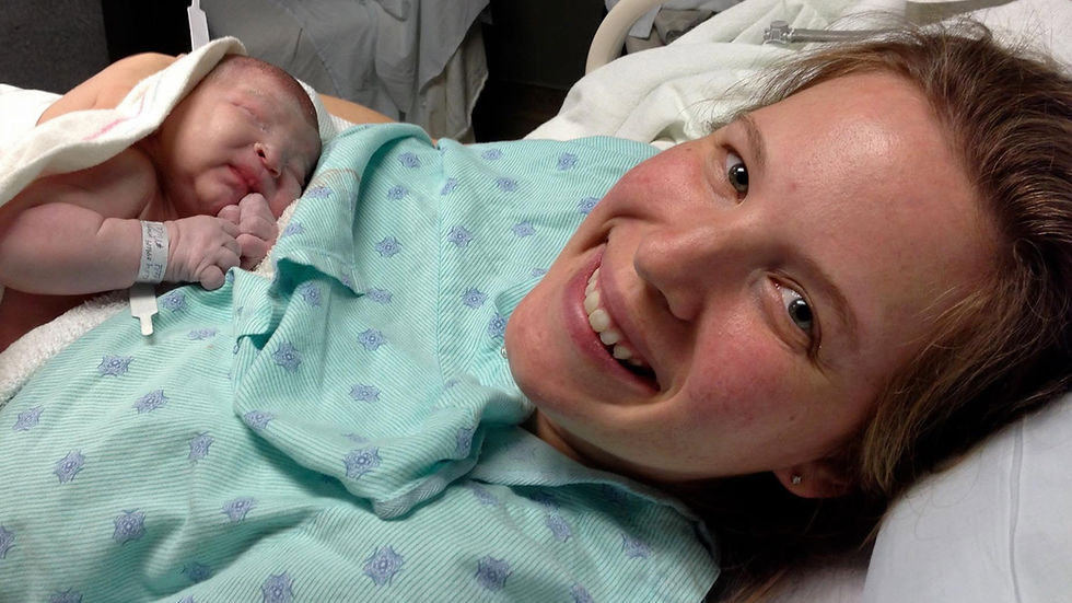 Smiling woman in hospital gown holds newborn wrapped in a towel. Baby wears ID wristband. Scene conveys joy in a medical setting.