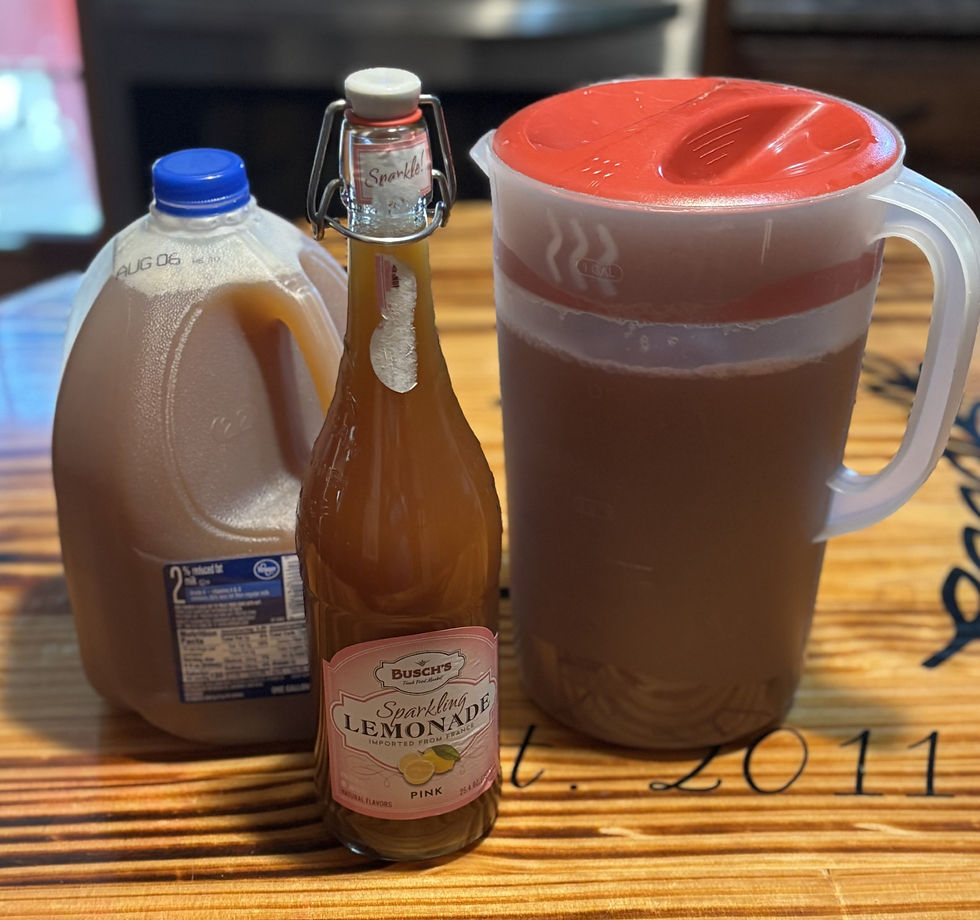 Jug with apple cider in a sparkling pink lemonade bottle, and a gallon of apple cider on wood table.