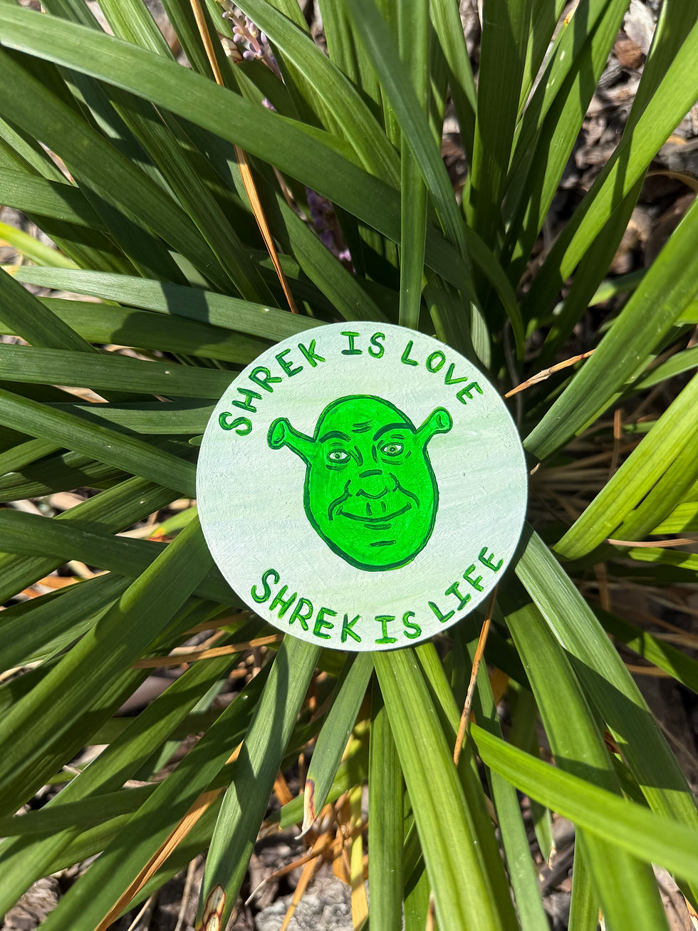 hand-painted Shrek Is Love Glow-in-the-Dark Magnet displayed on a plant
