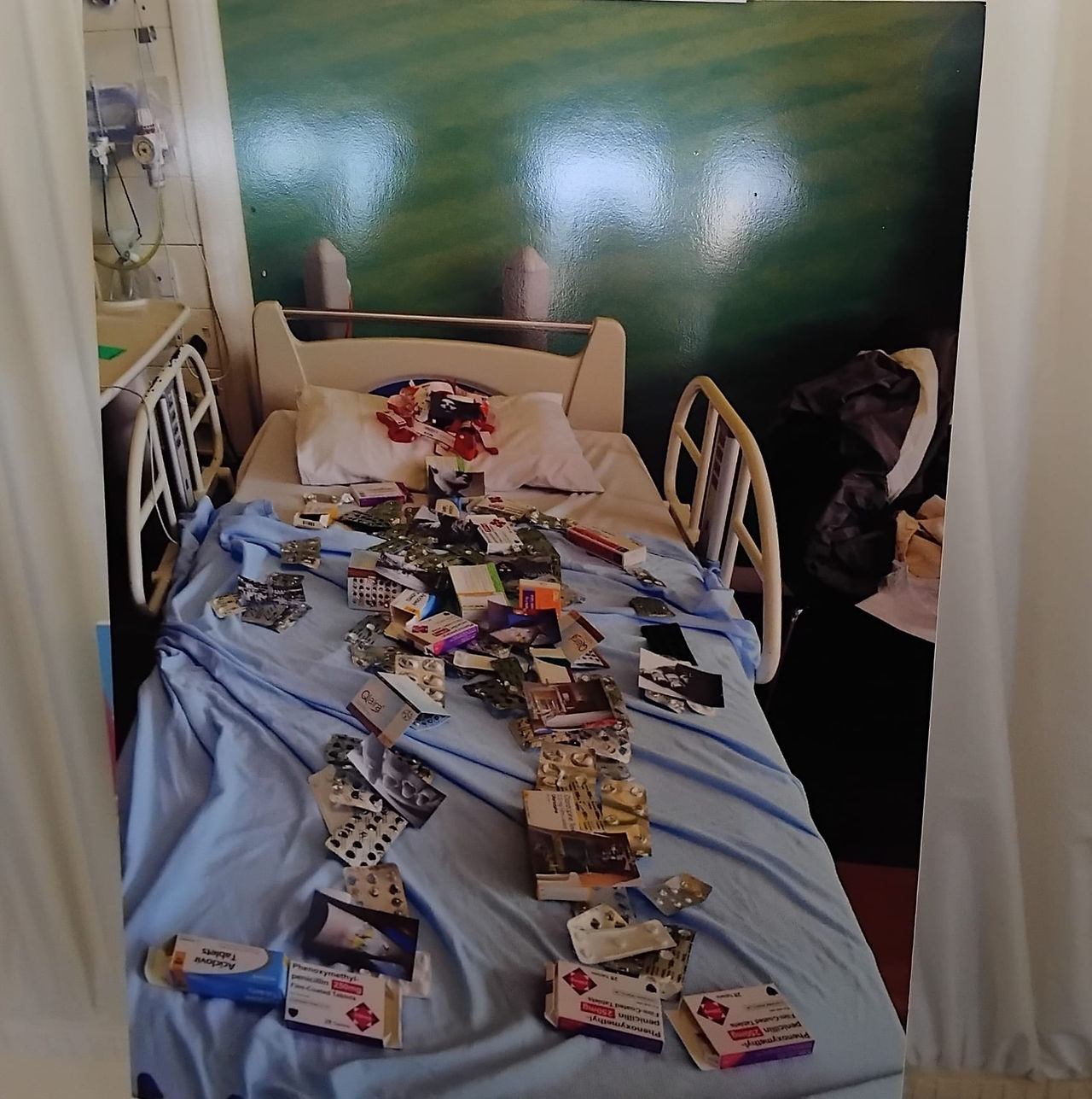 A patient lying on a hospital bed made out of pill boxes.