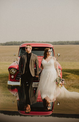 a couple and a red truck on their wedding day