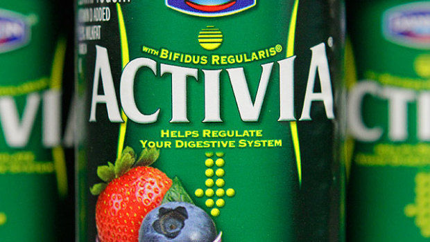Close up of a 4-ounce Activia container, which advertises its trademark named bacterial strain, bfidius regularis. The container also includes the product’s health claim, “Helps regulate your digestive system.” The curving vertical lines mimic the female abdomen included in Activia television commercials