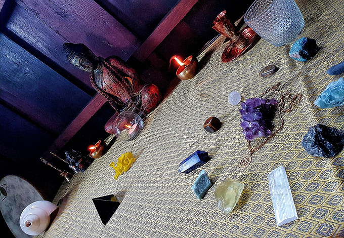 Buddha, crystals, flowers, oil lamps, Indian Hindu blowing Conch, Pooja bell on an alter in a spiritual healing house in Siem Reap where we offer shamanic practices like Tarot Reading, Energy Healing, Rune Reading, Sound Healing, and Astrology Reading.