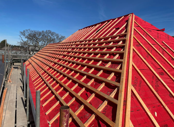 Roof construction underway with visible framework