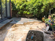 New porcelain patio installation with block paving edging and landscaped planting