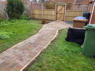 Block paved patio with decorative edging for a newly built home