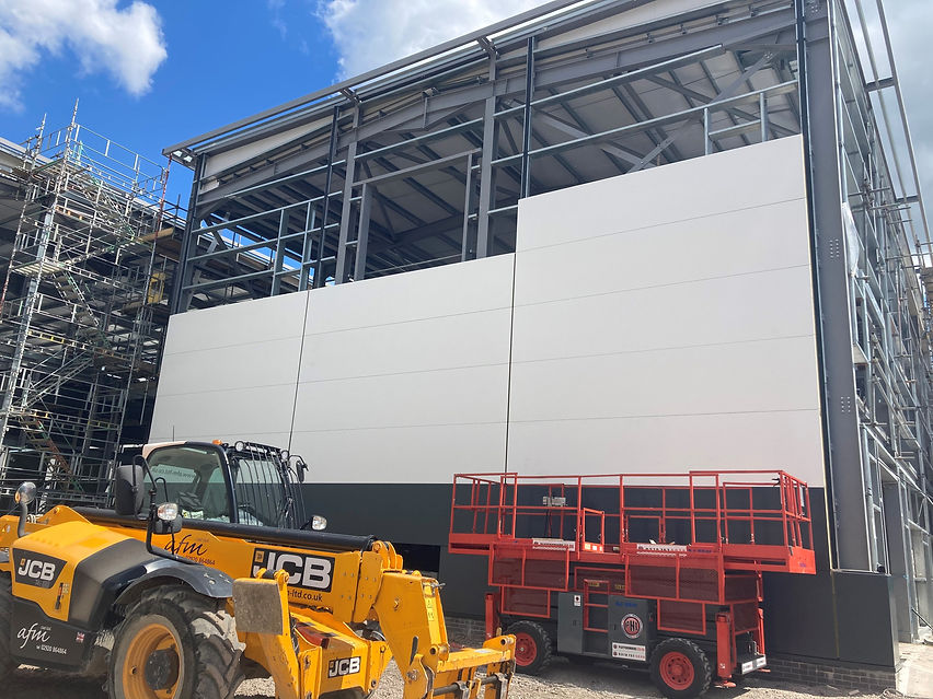 Construction site with a large white wall on a building under construction