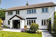 Large white house with lawn and flowers 