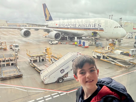 Child in front of a singapore airlines plane at heathrow airport
