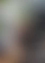 Hairdresser curls a client's hair in a salon with shelves, products, and green plants. One client wears a mask. Cozy and professional ambiance.