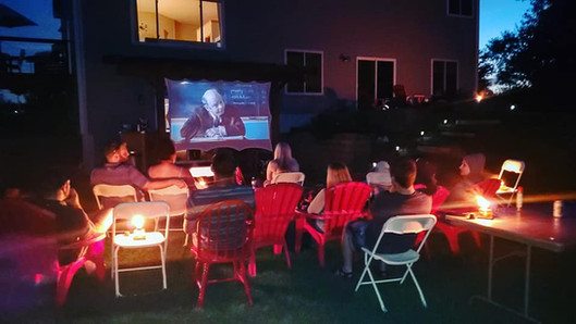outdoor movie night at custom home Minnesota with backyard seating and projector setup
