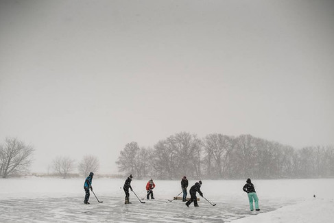 ice skating and hockey on private lake at custom home Minnesota during winter