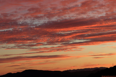 A still orange sky rests above clean silhouettes in this real sunset image - perfect for hotel wall displays.