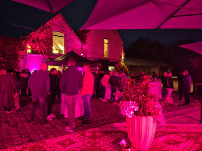 foule dans la cour du clos meraki, eclairée en rose