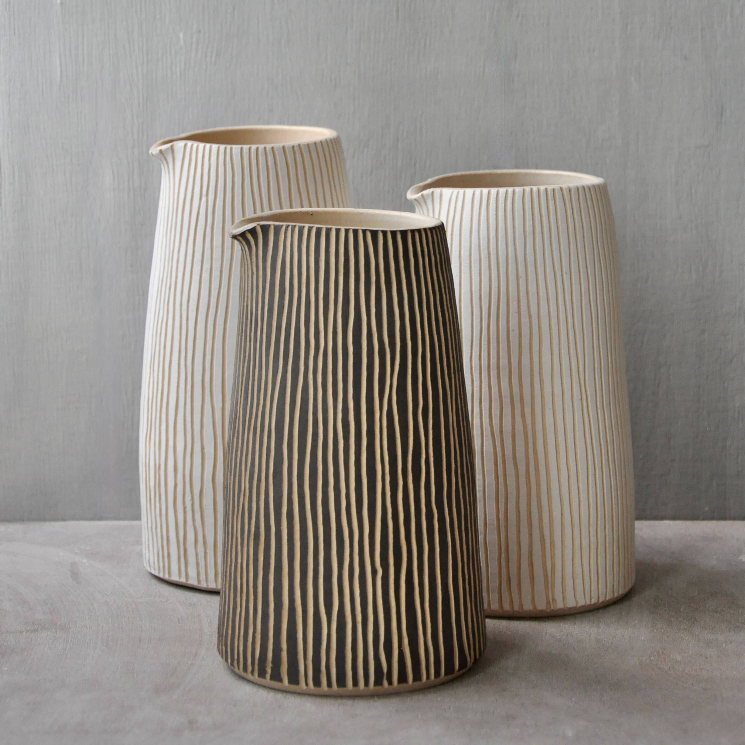 Tall white stoneware carafes with porcelain or black slip with sgraffito