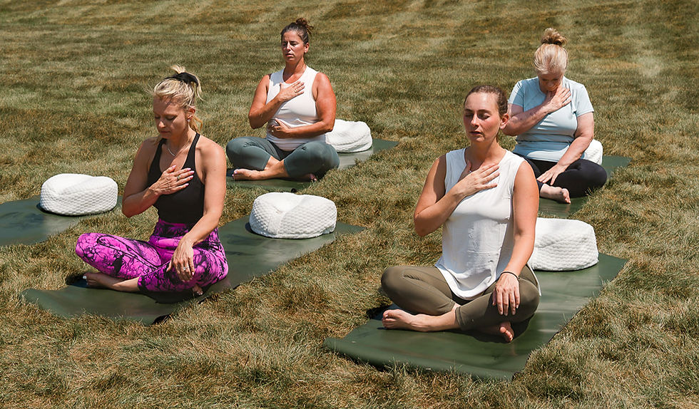 A group of people practicing meditation and mindfulness with their eyes closed.