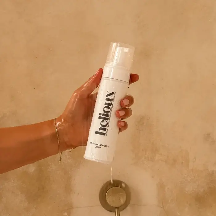 Thumbnail: tanned hand in shower holding 2 in 1 Primer & Self Tan Remover
