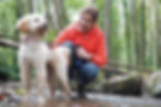 Dog walking with a white Cockerpoo in the woods