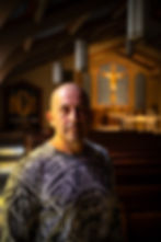 A priest in his clerics smiling while in church