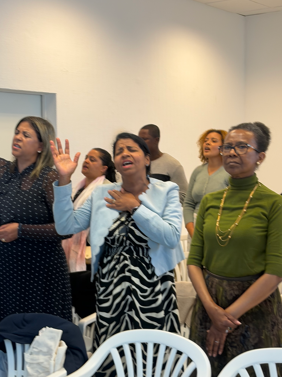Fieis em oração e louvor durante culto na igreja.