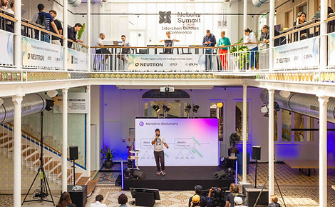 Corporate conference photographed in Paris, speaker on stage in a glass-roofed atrium