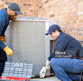 Two men repairing an outdoor AC unit