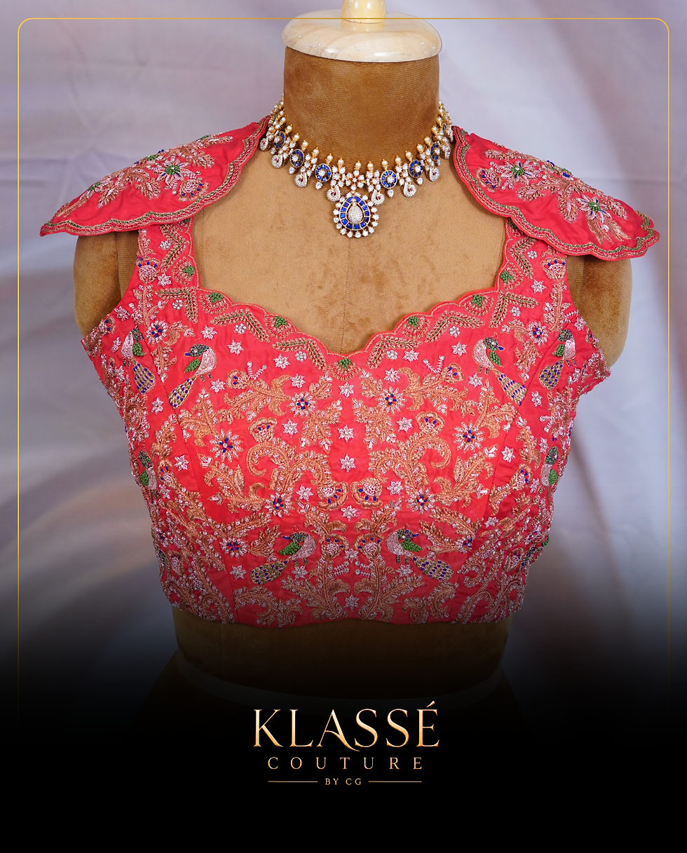 Coral pink embroidered blouse with floral detailing and scalloped neckline.