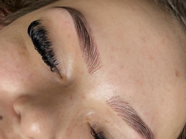 close-up woman with green eyes and dark lifted lashes