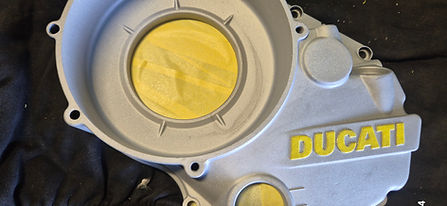 Grey Ducati clutch cover with yellow accents