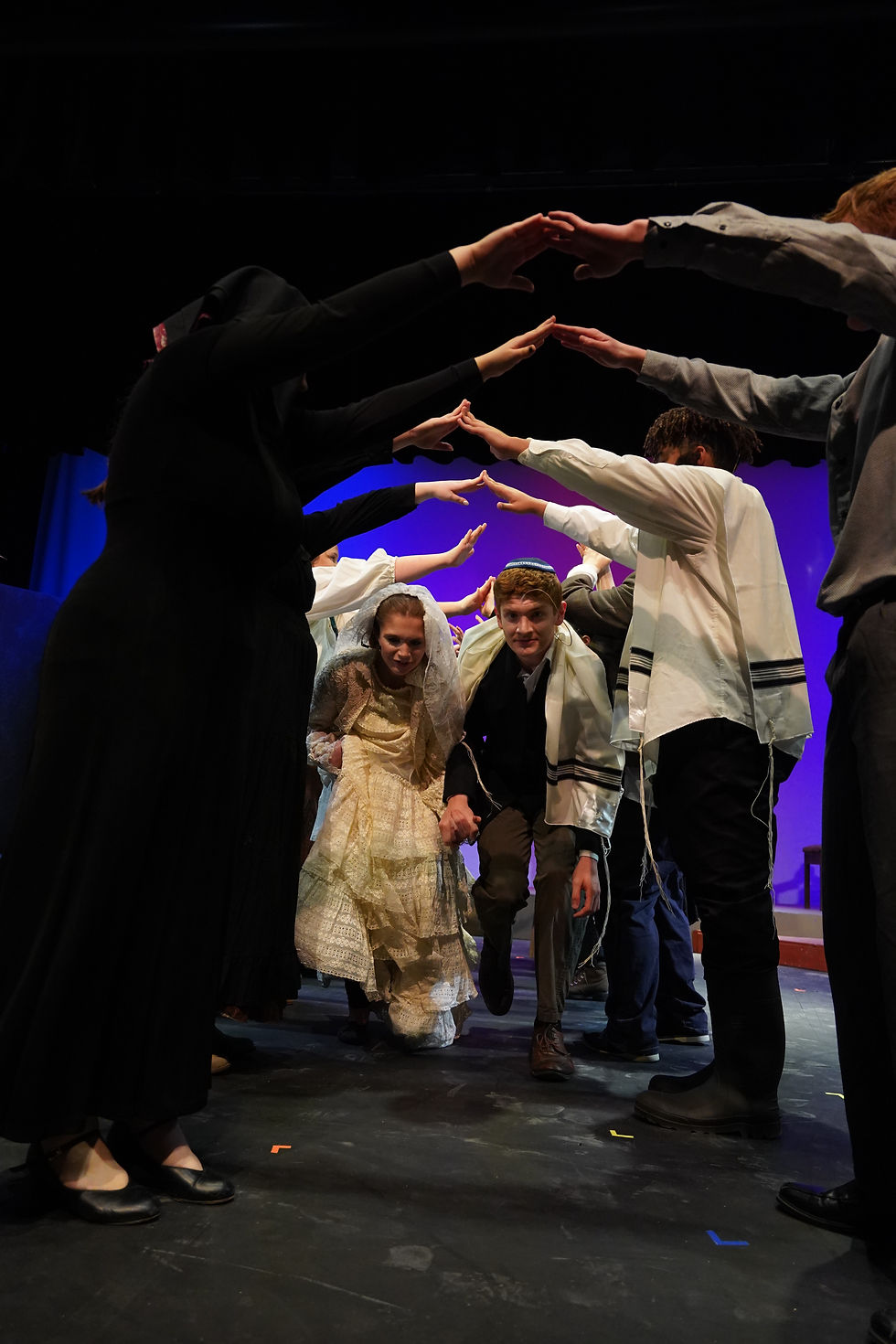 : Tzeitel (Carissa Krebs) and Motel (Ethan Glahn) make their way through the bridge during the wedding ceremony in Fiddler on the Roof.