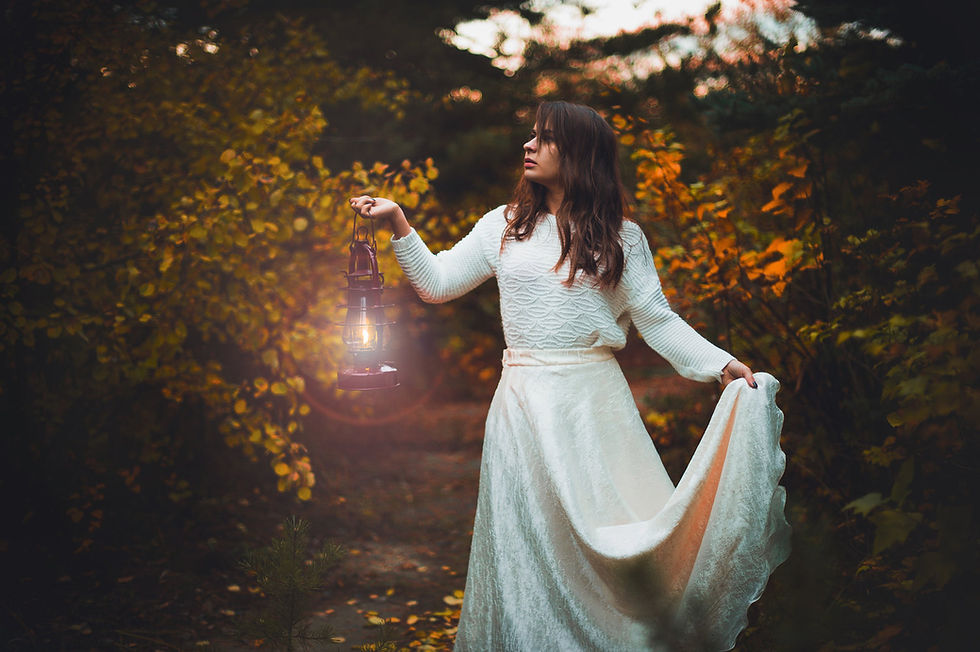 woman white dress walking in dark with lantern