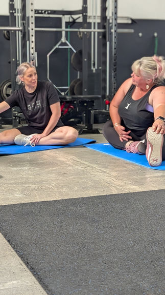 Three women stretching on mats at MBS Fitness Bridgewater.