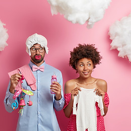 un couple de jeune parents avec des accessoires pour bébé de façon amusante