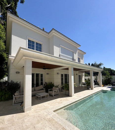 פרגולת אלומיניום יוקרתית בגוון דמוי עץ מרחפת כתקרת הצללה לאורך פינת הישיבה בחצר בבית פרטי, מבט חזיתי משמאל