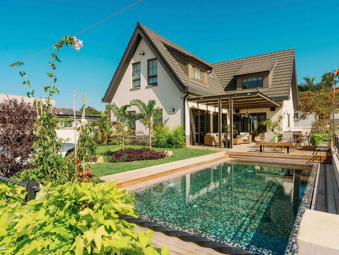 גג רעפים גלוי בסגנון הולנדי יוקרתי עם קונסטרוקציית עץ גושני, מבט חזיתי על בית פרטי מהחצר