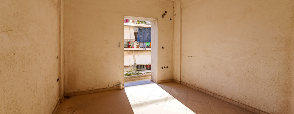 Beautiful and stylish shot with sunny stripes from the door on the floor inside the bedroom and a view of the neighboring house