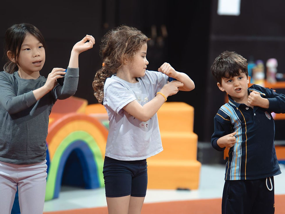 Kids warming up in a circus class with colourful equipment behind them