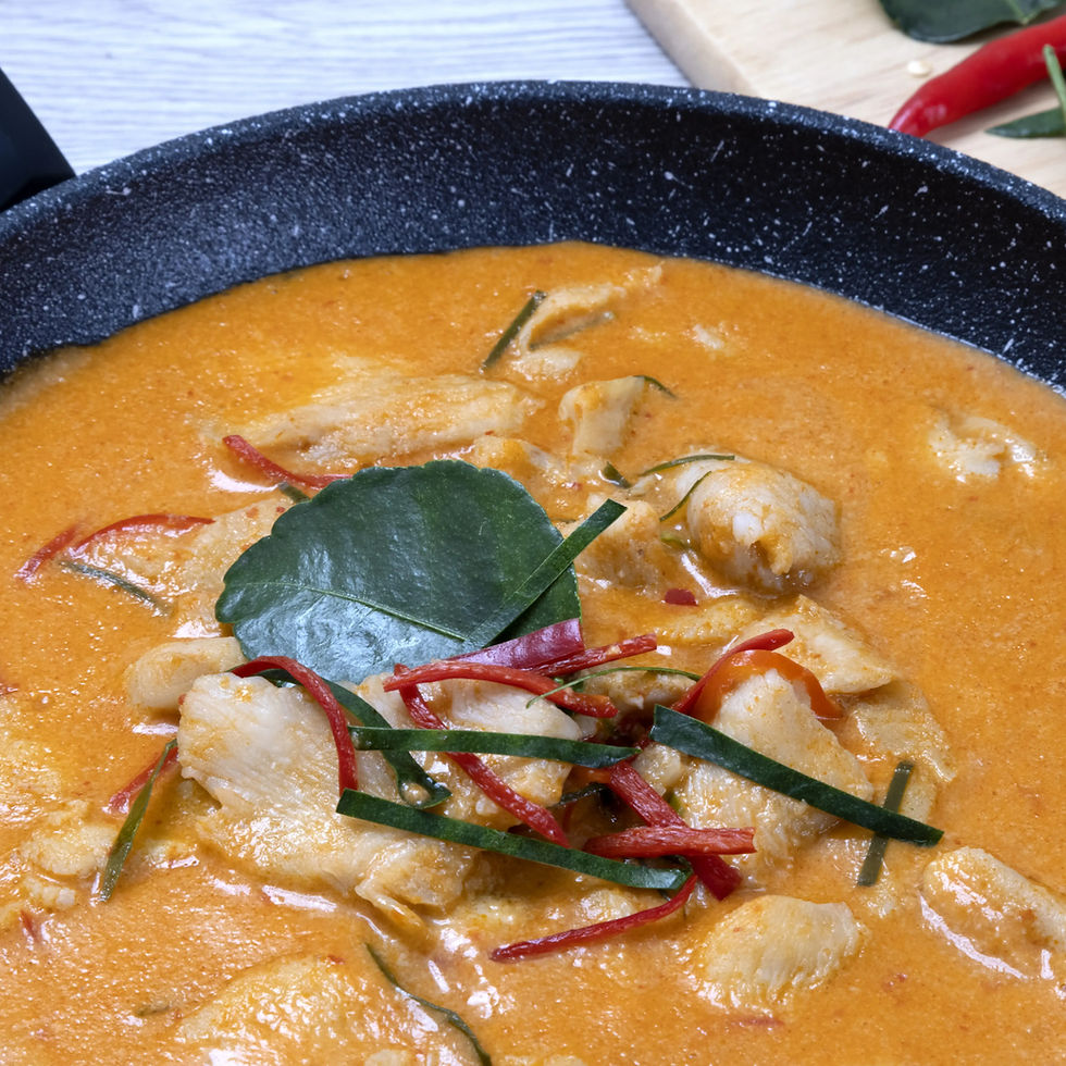 Curry rouge thaïlandais cuisant dans une poêle avec tous les ingrédients ajoutés