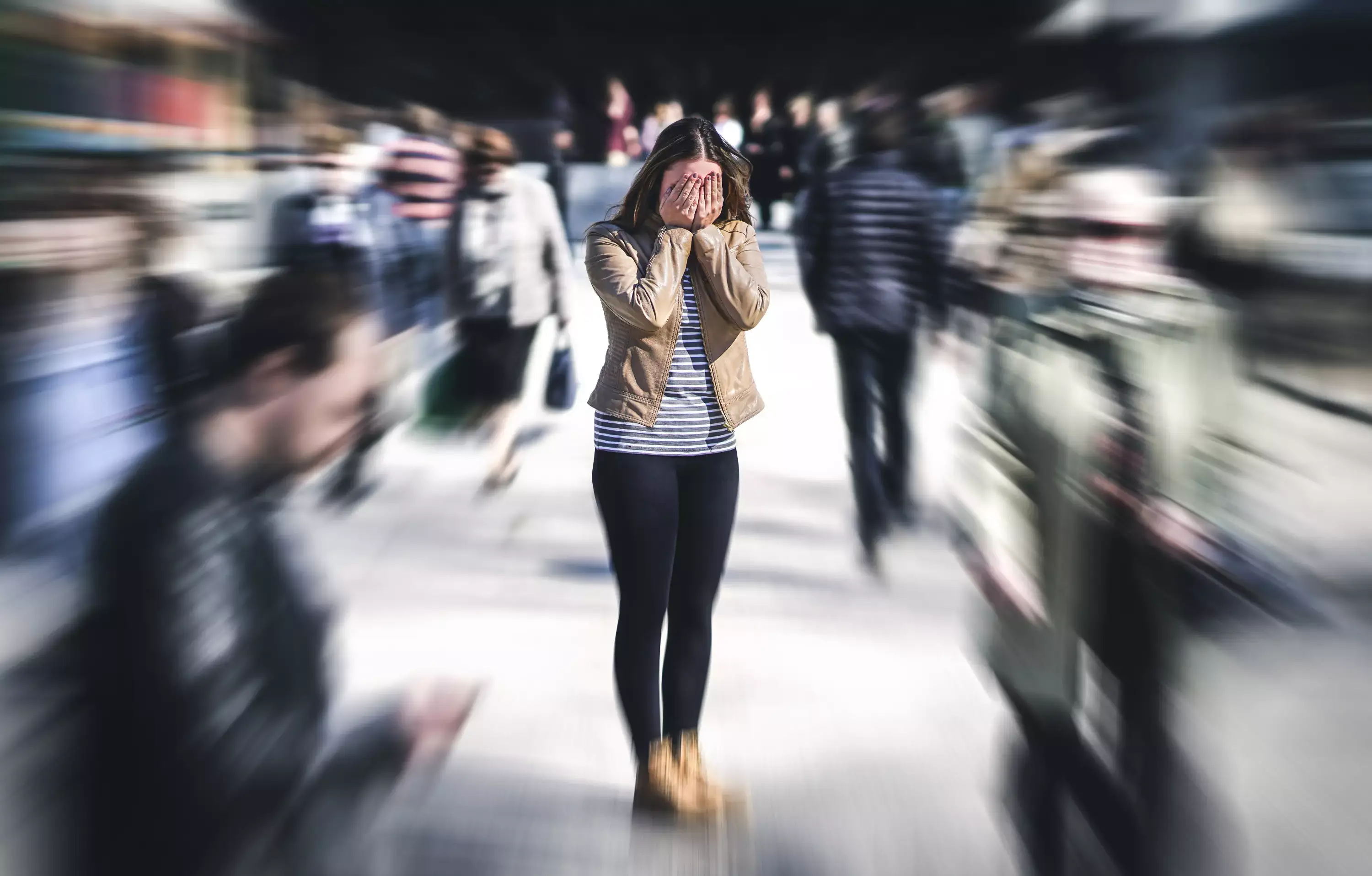 Girl covering her eyes in a crowd, hoping for fear and a phobia relief.webp