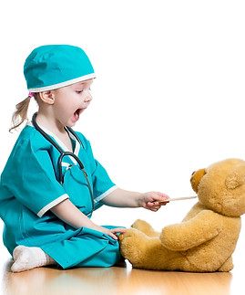 bambina che gioca al dottore con pupazzo