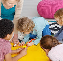 gruppo di bambini che disegnano a terra