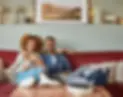 Millenial couple sitting on the couch in their living room doing online therapy in Calgary