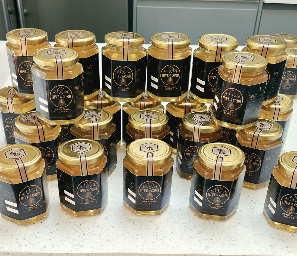 Rows of hexagonal honey jars with gold lids and black labels