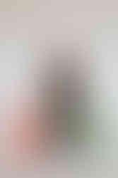 A model wearing an all black leather outfit, posing with sunglasses and the bottom halves of two mannequins.